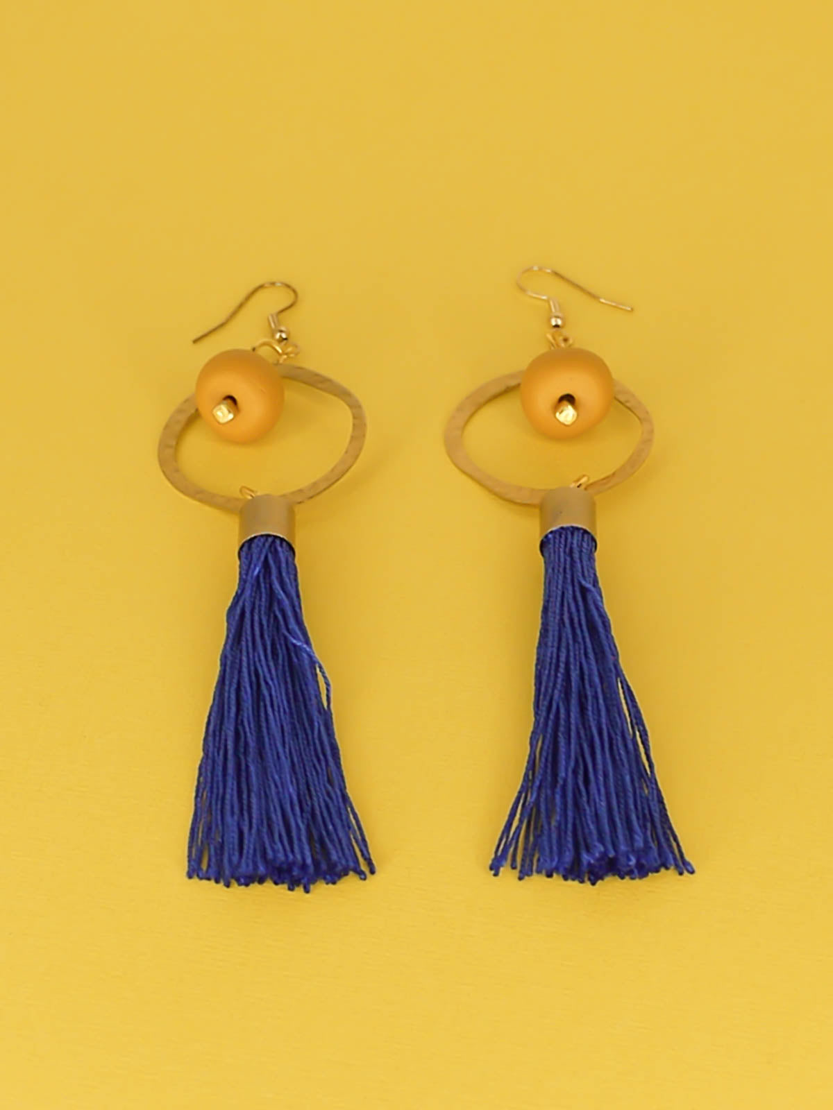 Long tassel statement earrings with gold plated ear wires, connected to a textured brass hoop with a mustard polymer clay bead dangling in the centre & a cobalt blue long tassel hung from the hoop