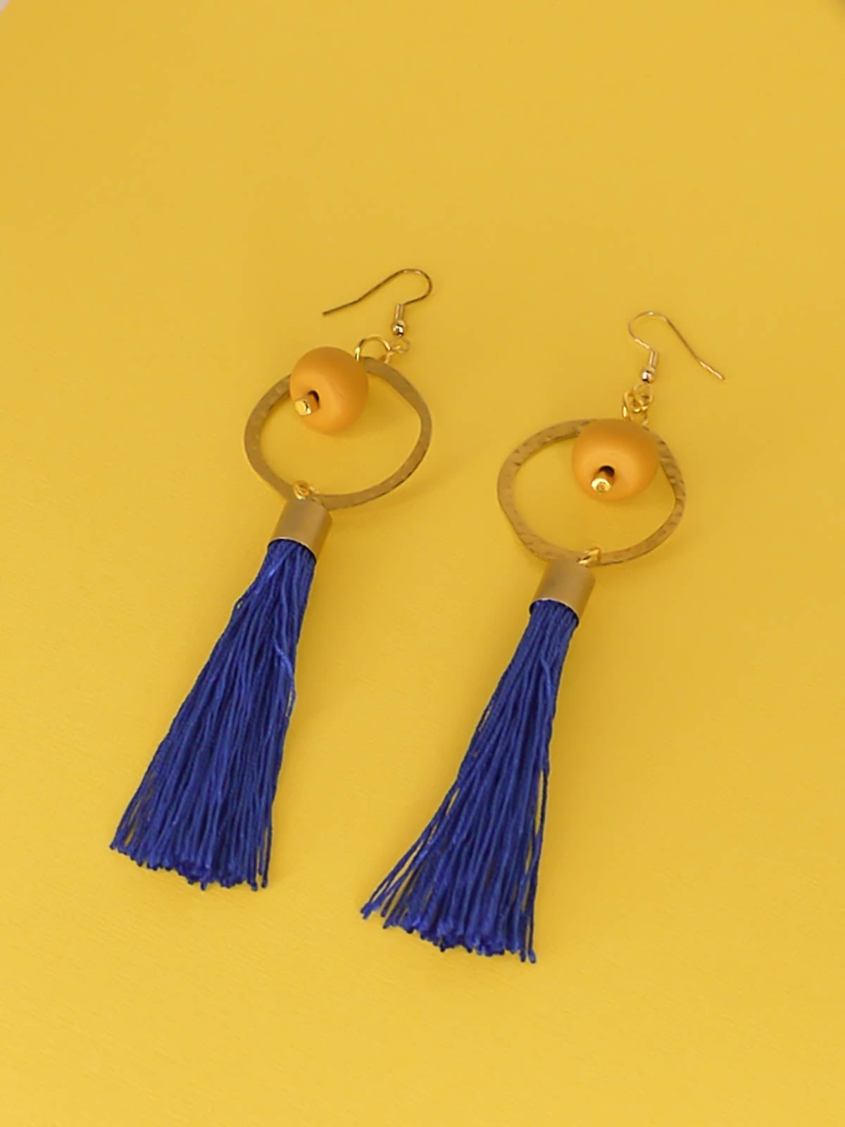 Long tassel statement earrings with gold plated ear wires, connected to a textured brass hoop with a mustard polymer clay bead dangling in the centre & a cobalt blue long tassel hung from the hoop