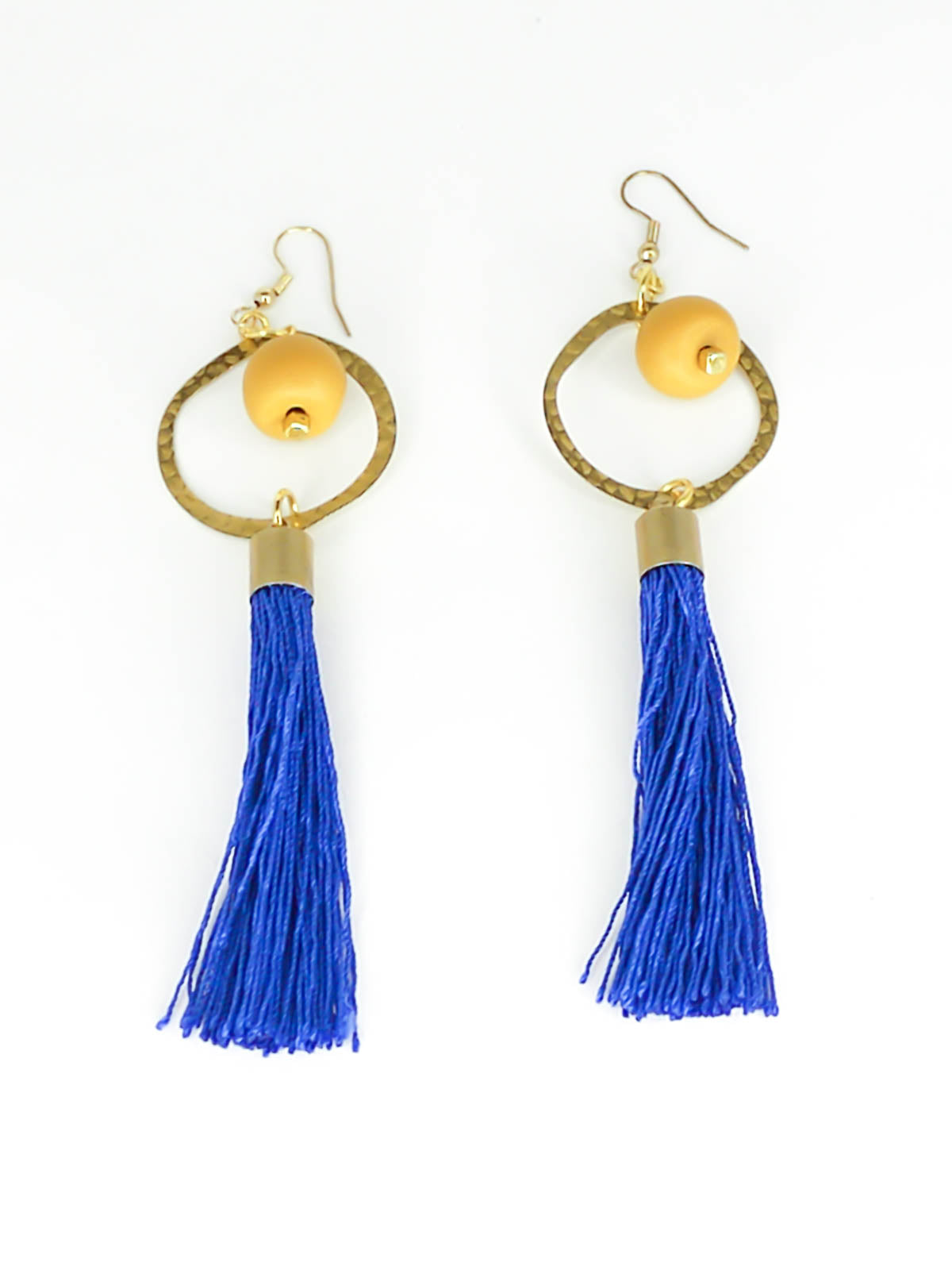 Long tassel statement earrings with gold plated ear wires, connected to a textured brass hoop with a mustard polymer clay bead dangling in the centre & a cobalt blue long tassel hung from the hoop