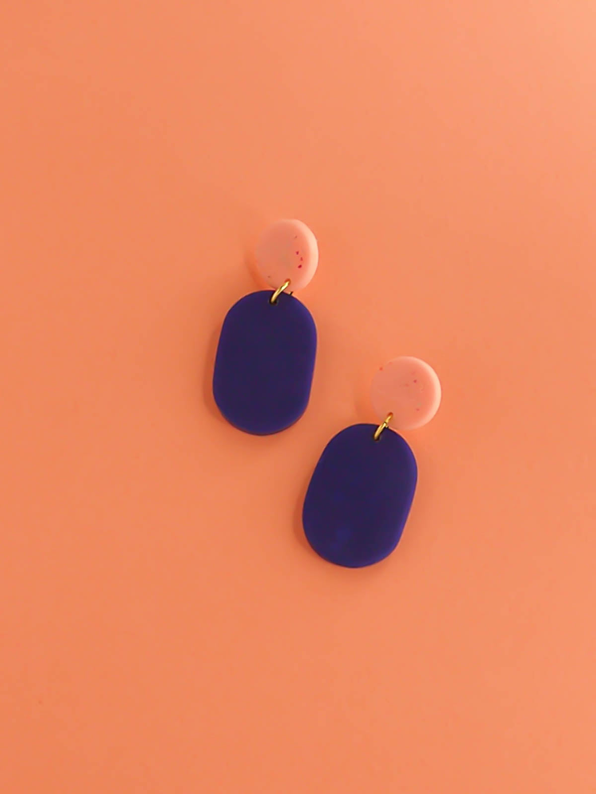 Colour block polymer clay statement earrings with a cobalt blue rectangle and pink speckled stud with stainless steel earring posts