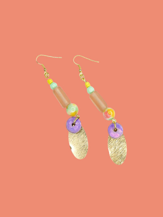 Colourful beaded brass dangle statement earrings with glass and ceramic beads and a textured brass charm, hung from gold plated ear wires