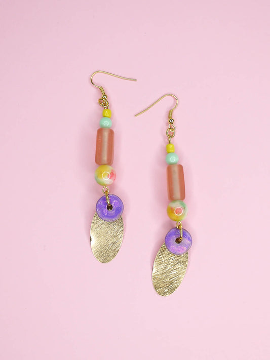 Colourful beaded brass dangle statement earrings with glass and ceramic beads and a textured brass charm, hung from gold plated ear wires