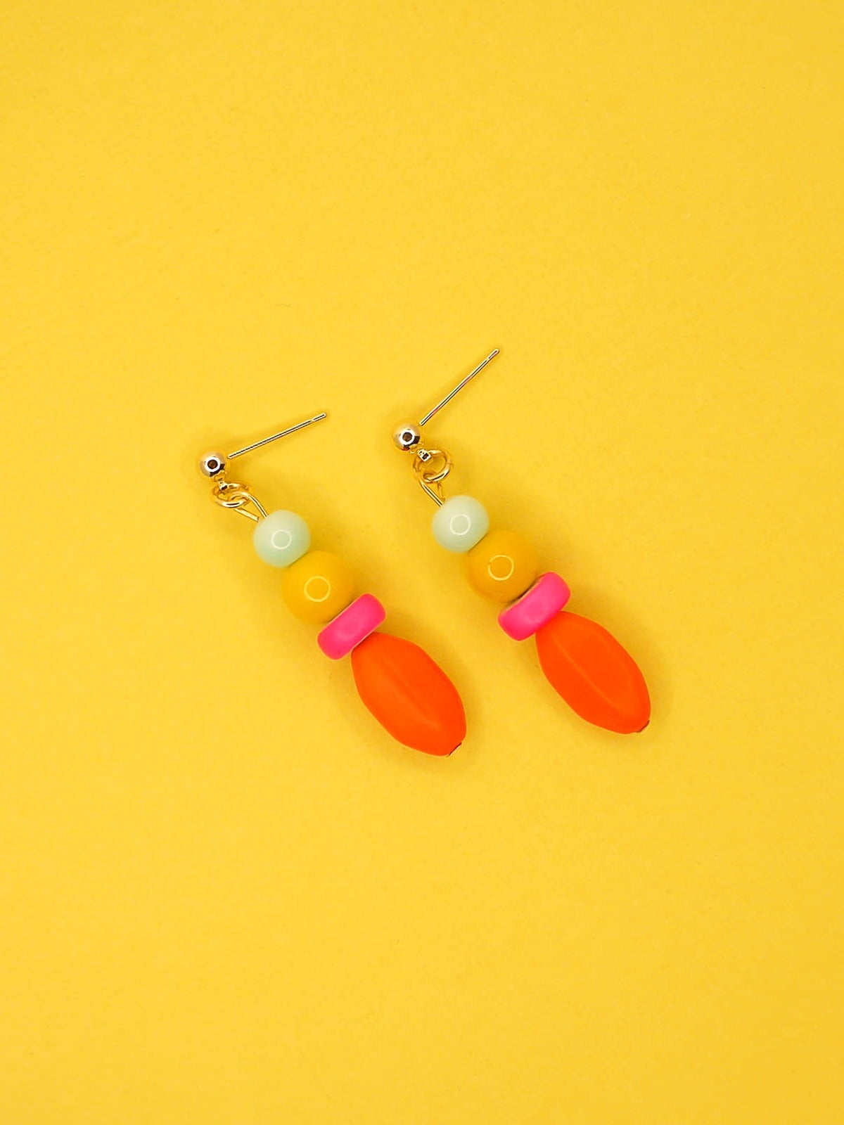 Colourful bright bead drop earrings made of a mix of glass, wood and resin beads in multi colours of mint, yellow, hot pink and orange. Hung from 24k gold plated brass ball studs.