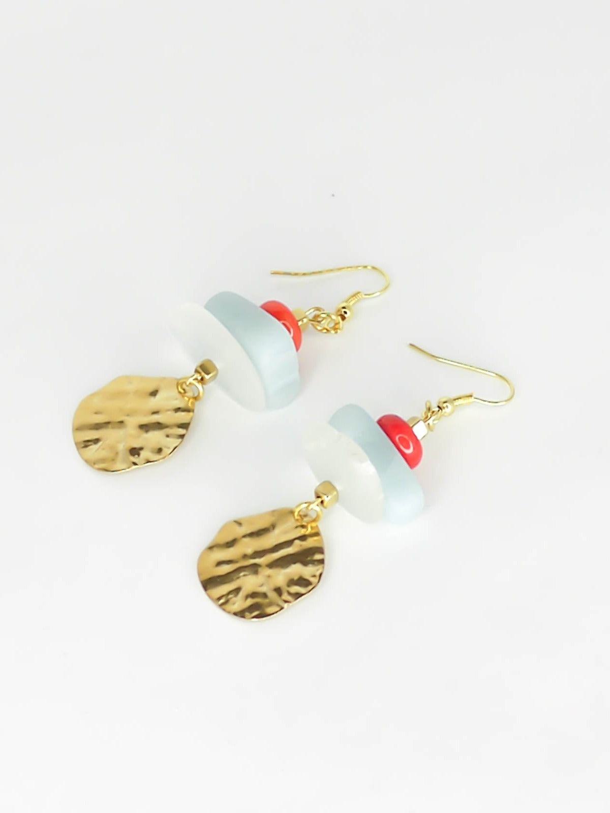 Gemstone crystal earrings with a stack of coral, amazonite and crystal quartz beads with a textured brass medallion charm, hung from gold plated ear wires