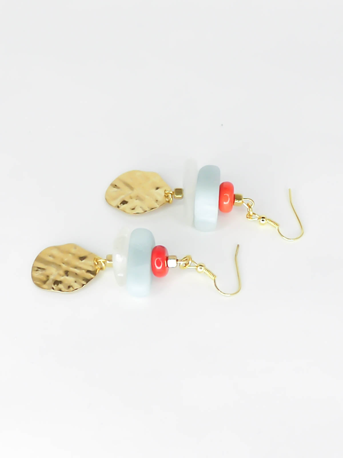 Gemstone crystal earrings with a stack of coral, amazonite and crystal quartz beads with a textured brass medallion charm, hung from gold plated ear wires