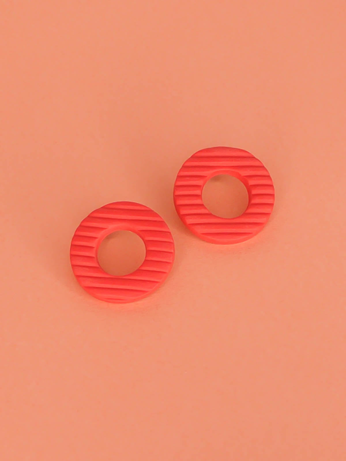 Coral hoop stud statement earrings made out of polymer clay with a fluted striped texture and stainless steel posts