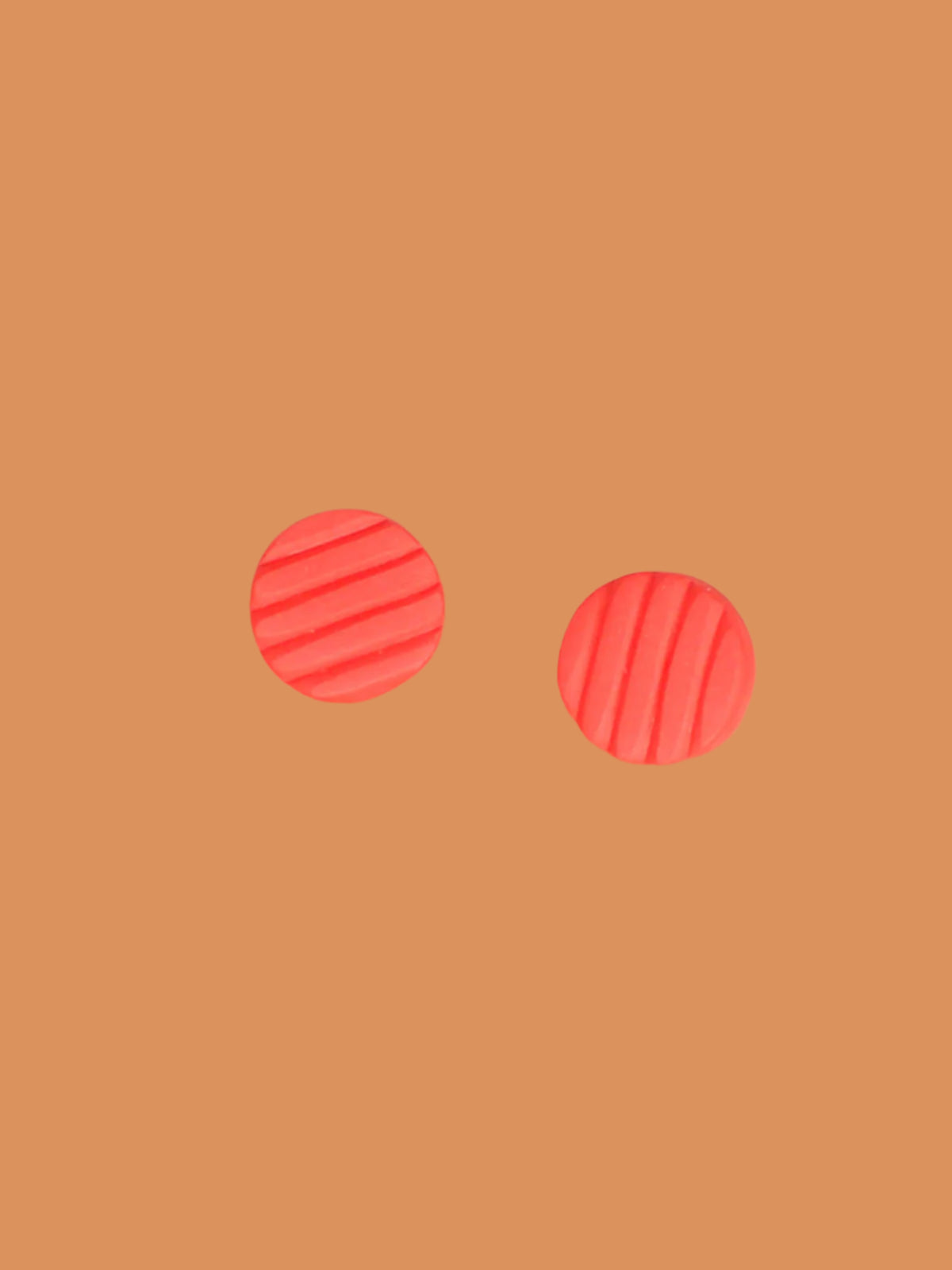 Mini coral polymer clay studs in a textured stripe