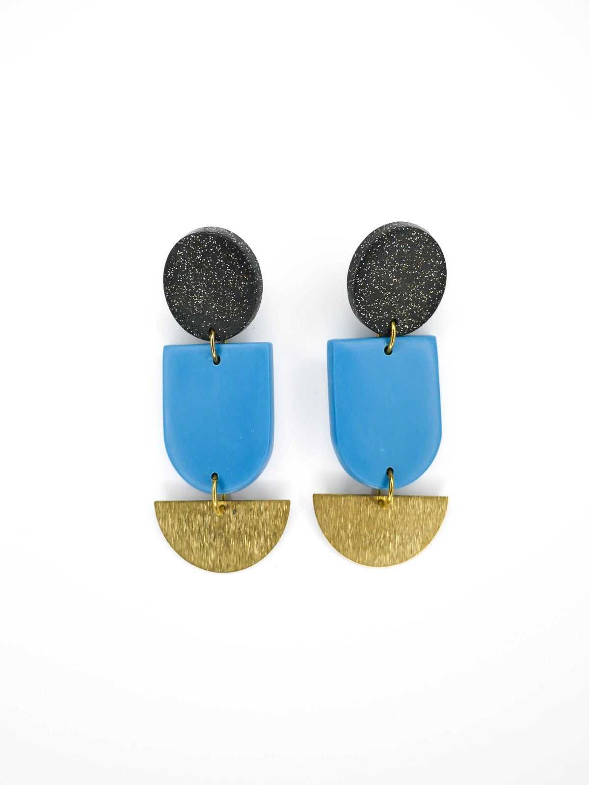 Geometric polymer clay dangle earrings with a black glitter circle stud, connected to a blue arch & a textured brass semi circle