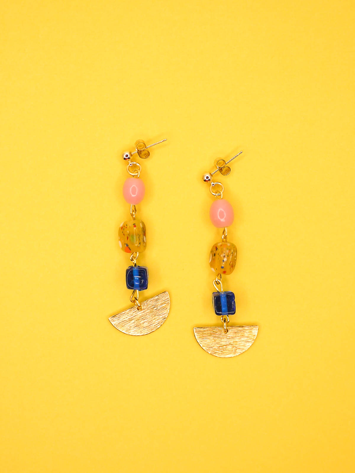 Colourful glass bead dangle earrings in pink, speckled yellow and blue glass beads with a textured brass semi circle charm, hung from 24k gold plated ball studs