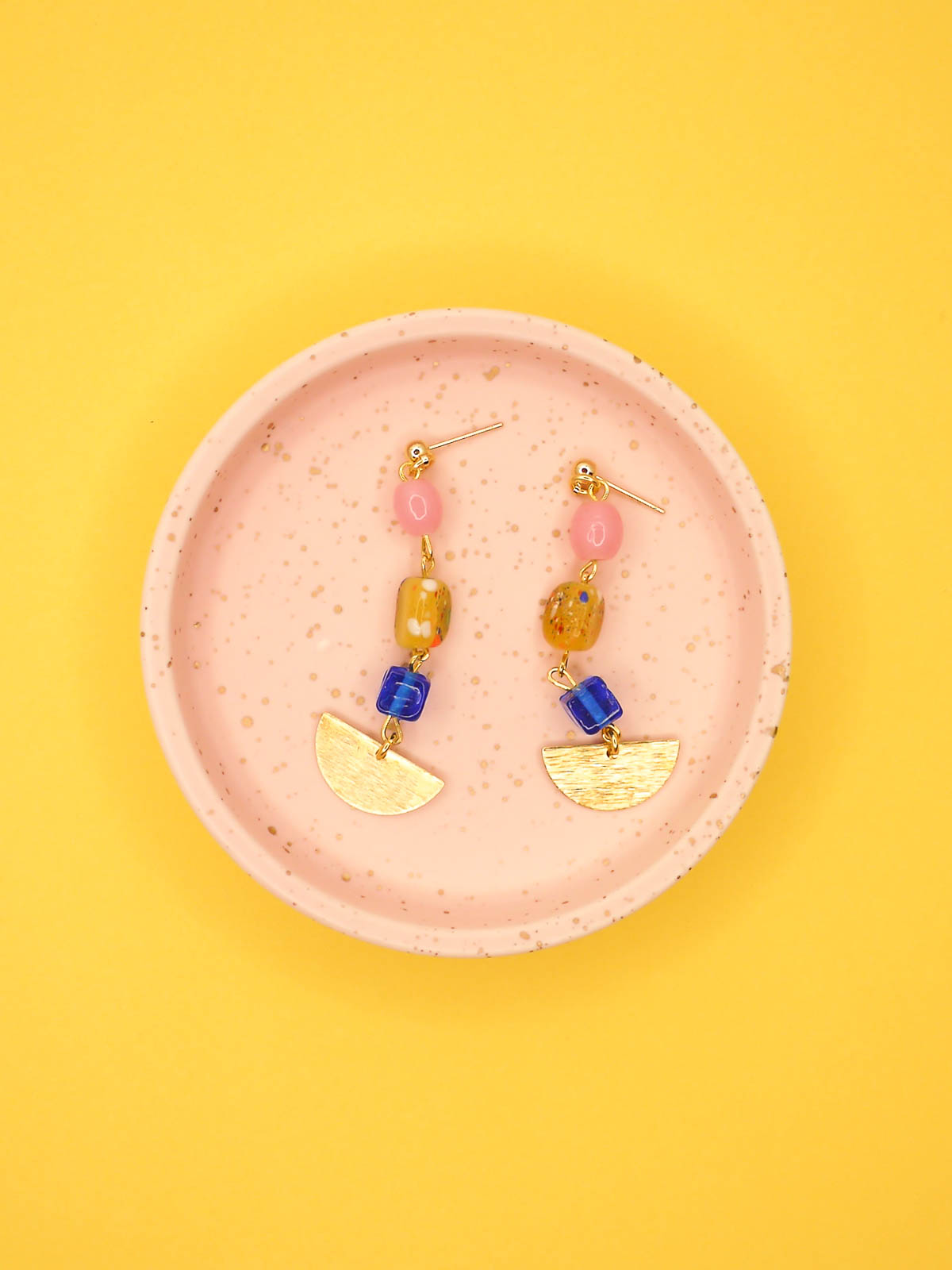 Colourful glass bead dangle earrings in pink, speckled yellow and blue glass beads with a textured brass semi circle charm, hung from 24k gold plated ball studs