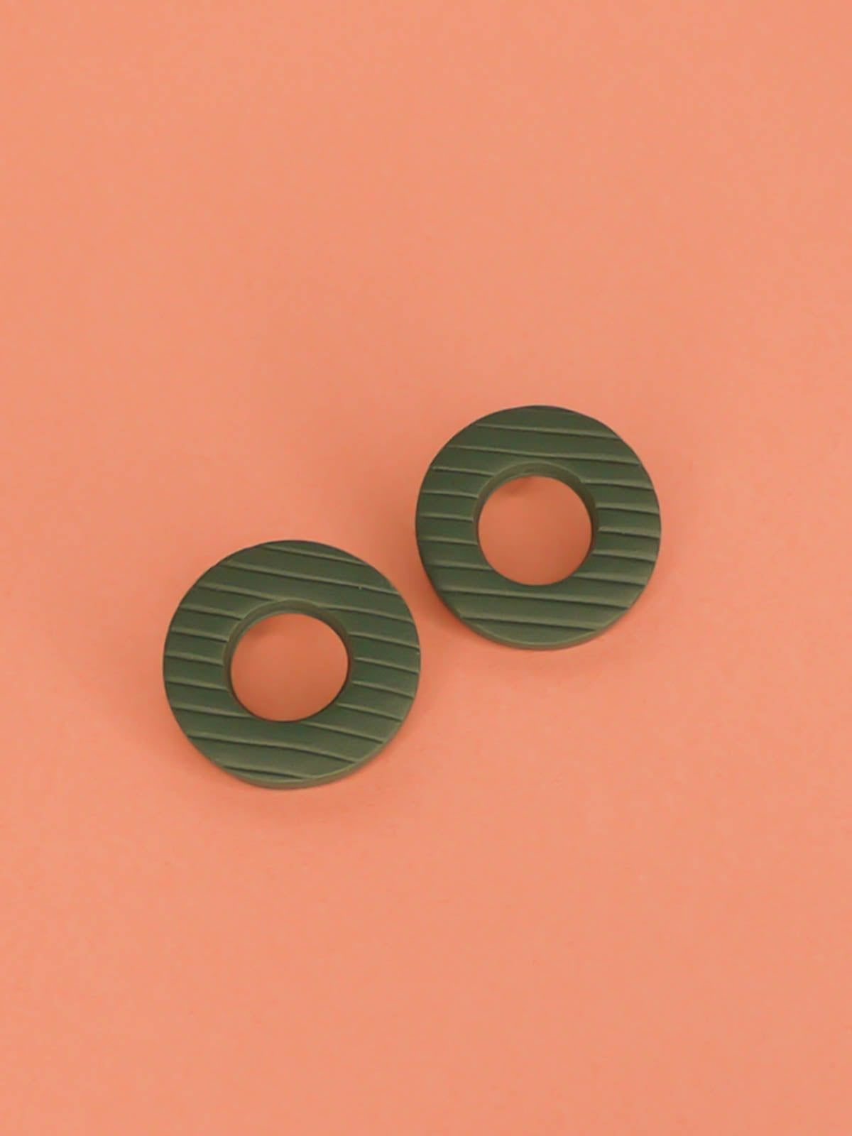 Green hoop stud earrings made out of polymer clay with a striped texture