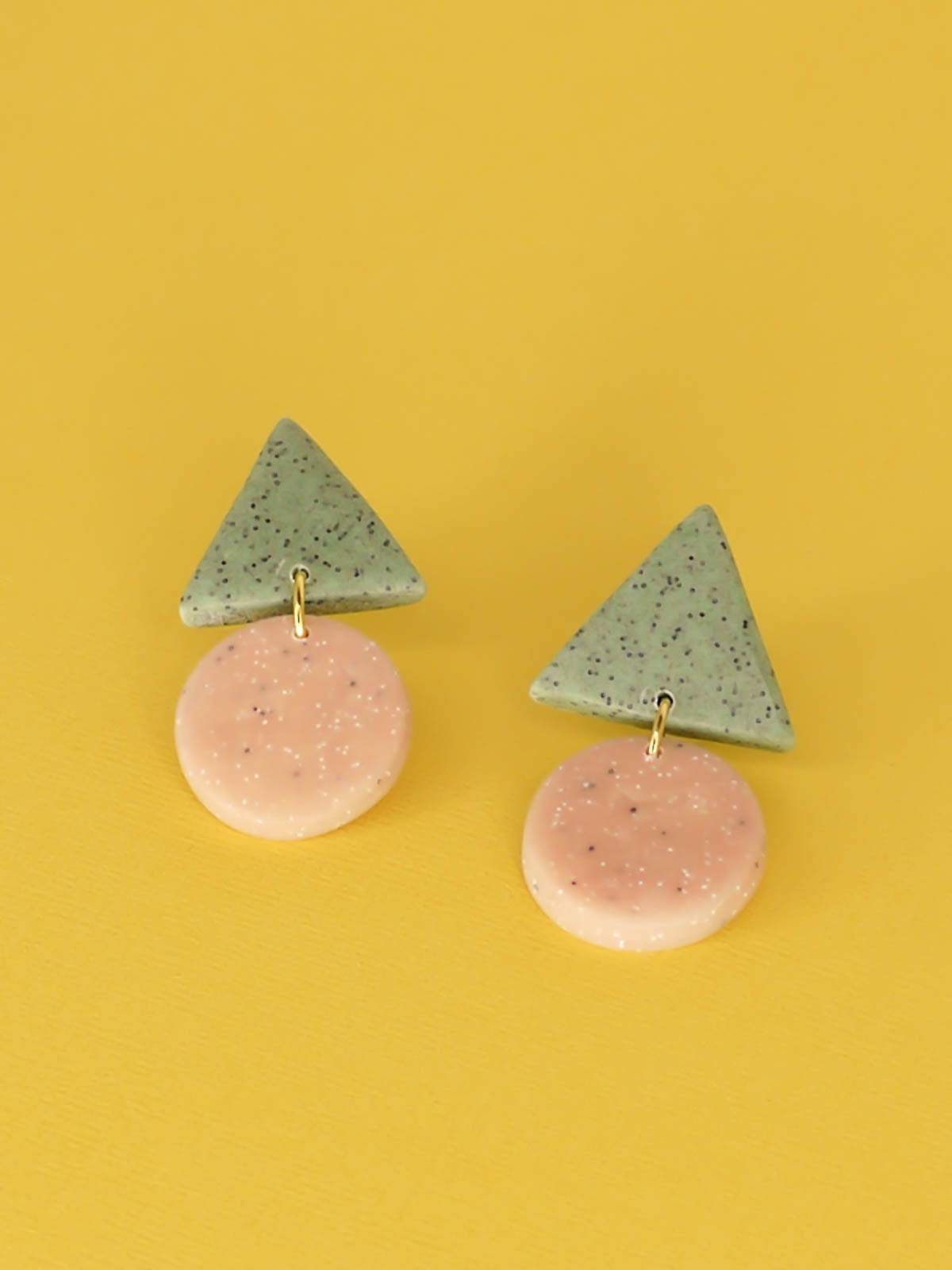 Geometric stud dangle earrings with a granite green triangle stud and a peach granite circle with stainless steel posts