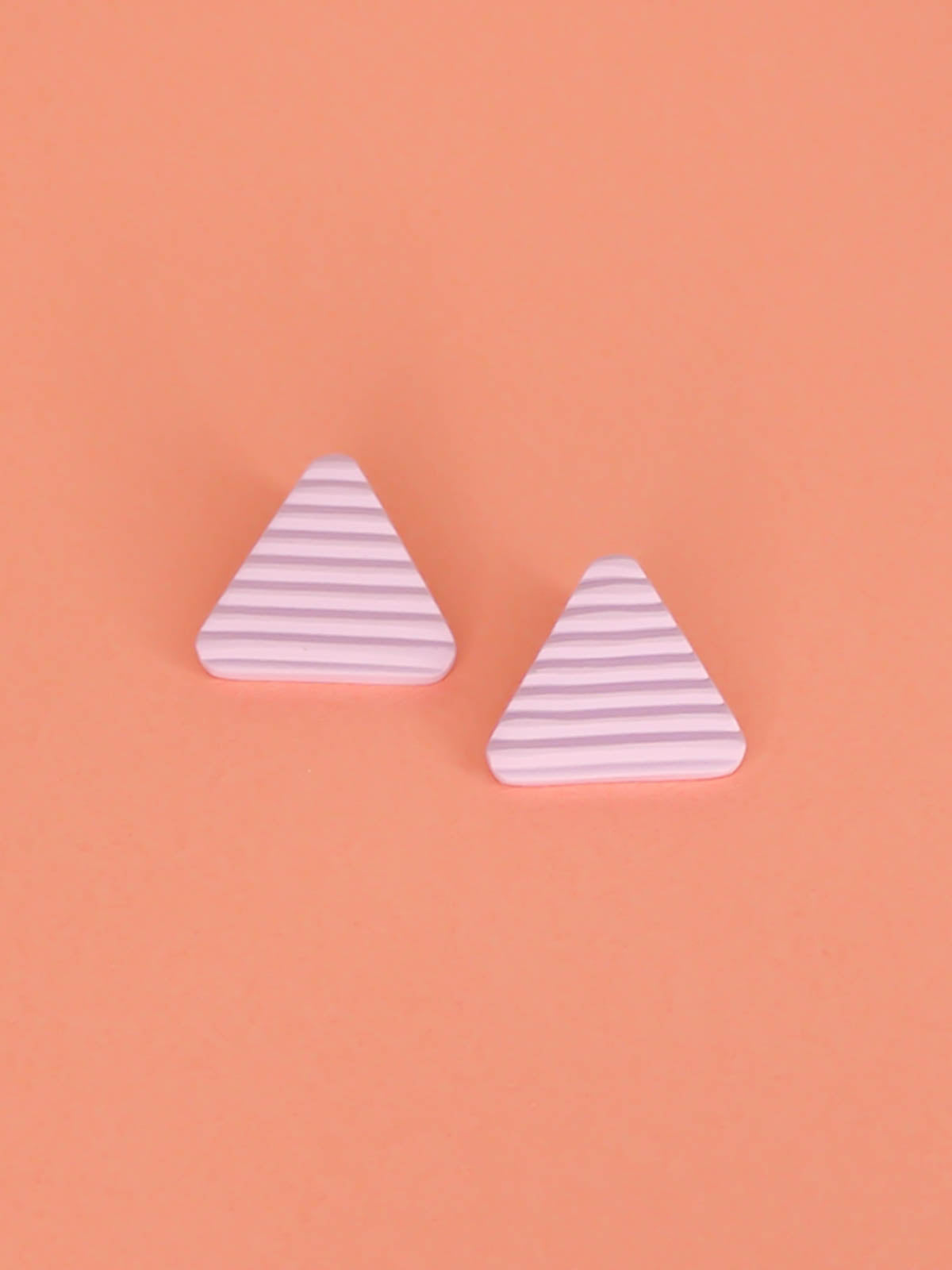 Lightweight lilac polymer clay triangle stud earrings in a fluted striped texture with stainless steel studs.