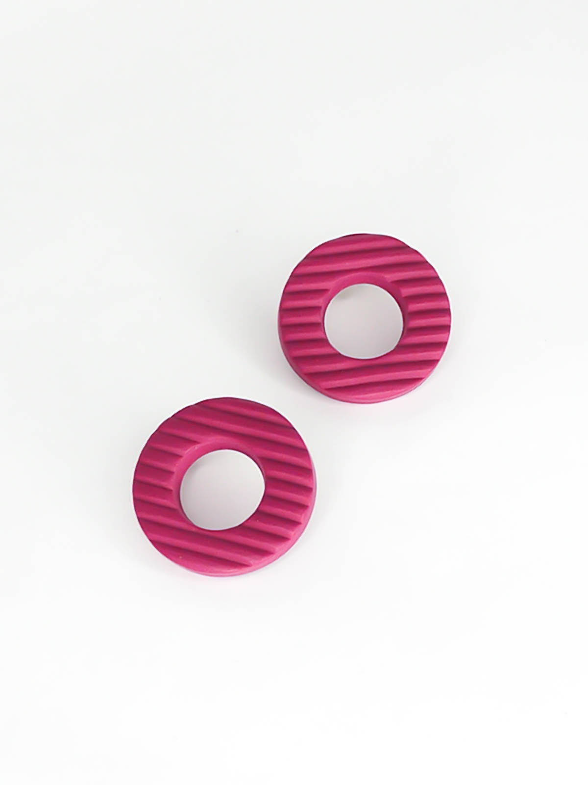 Magenta hoop stud polymer clay earrings with a fluted striped texture and stainless steel posts