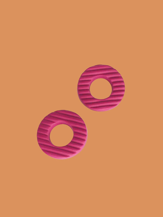 Magenta hoop stud polymer clay earrings with a fluted striped texture and stainless steel posts