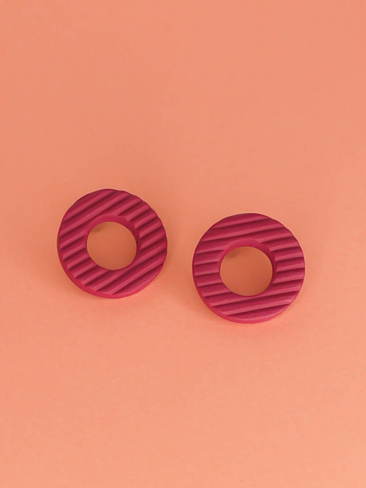 Magenta hoop stud polymer clay earrings with a fluted striped texture and stainless steel posts