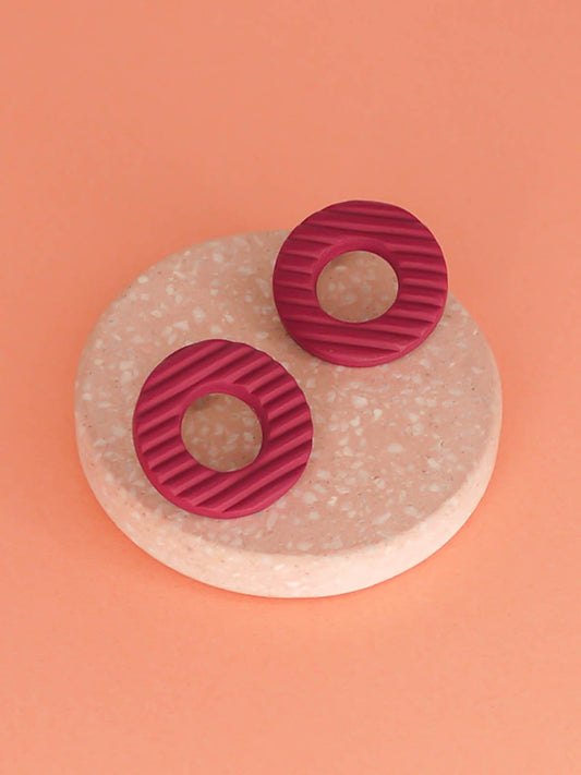 Magenta hoop stud polymer clay earrings with a fluted striped texture and stainless steel posts