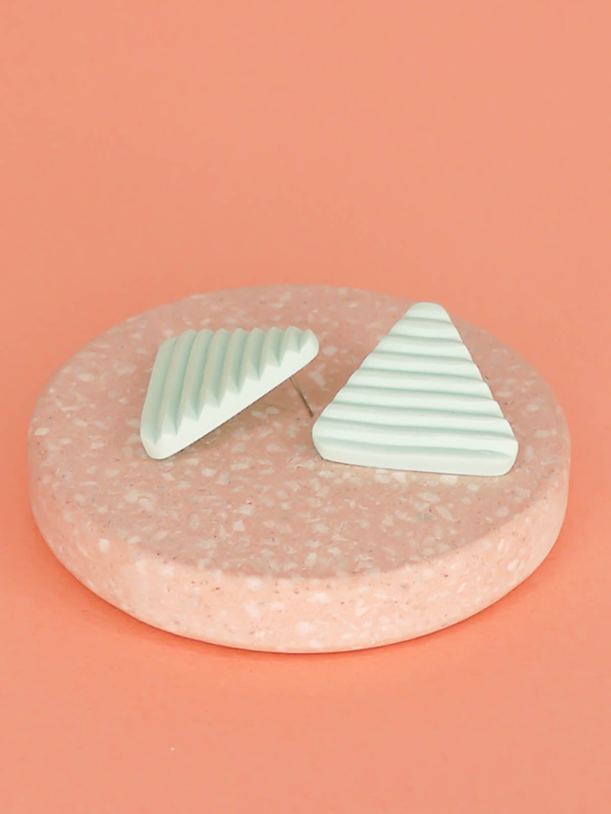 Lightweight mint polymer clay triangle stud earrings in a fluted striped texture with stainless steel studs.