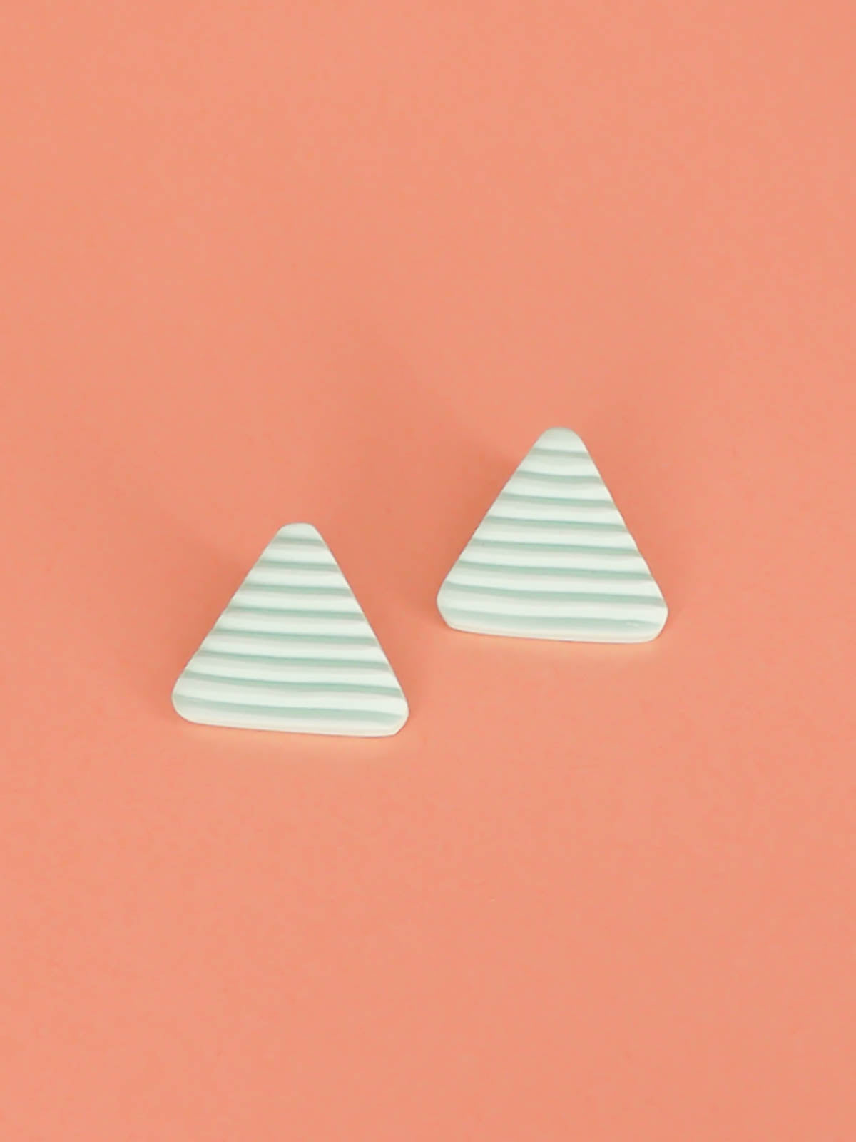 Lightweight mint polymer clay triangle stud earrings in a fluted striped texture with stainless steel studs.