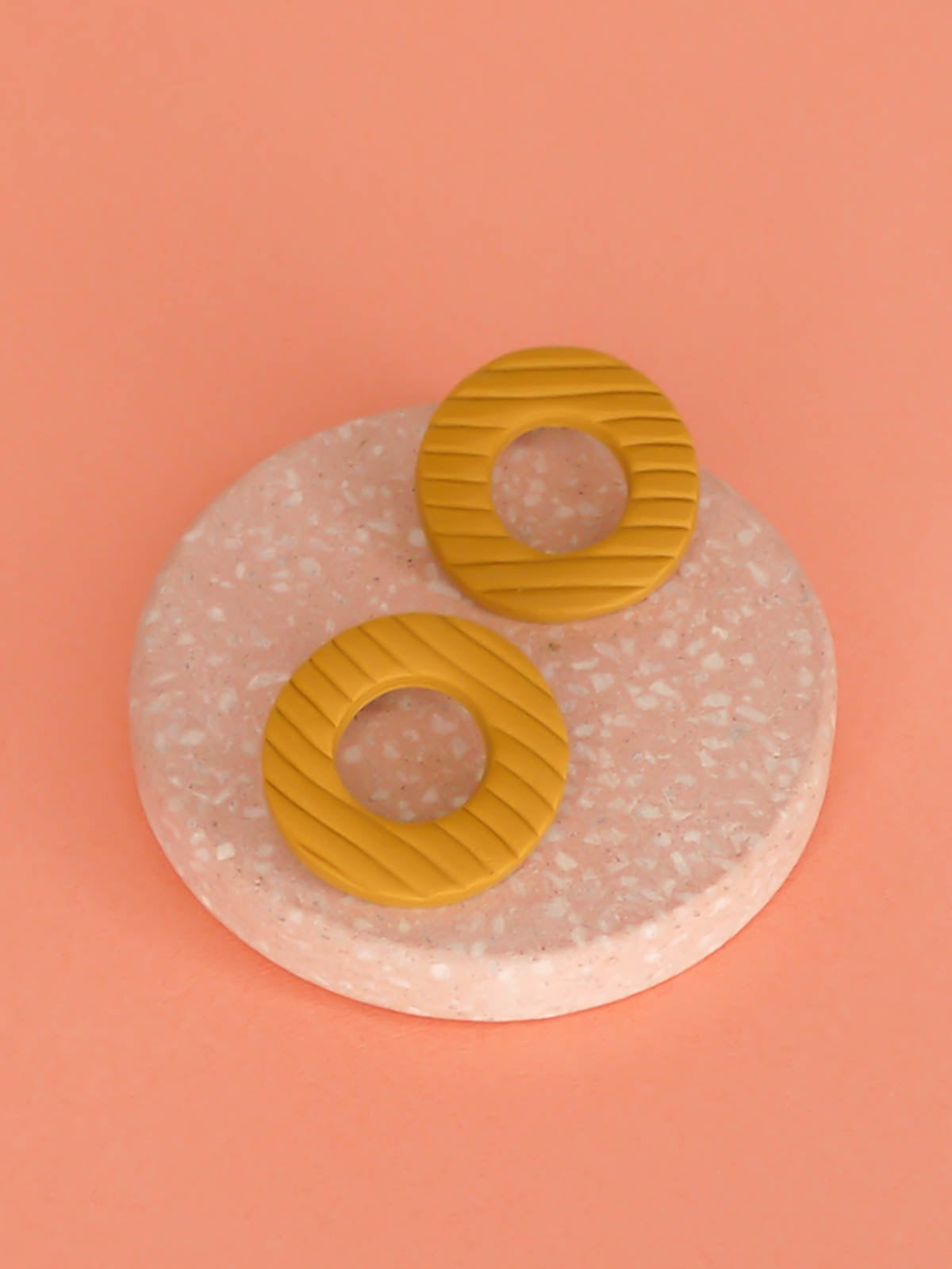 Mustard hoop stud statement earrings made out of polymer clay with a fluted striped texture and stainless steel posts