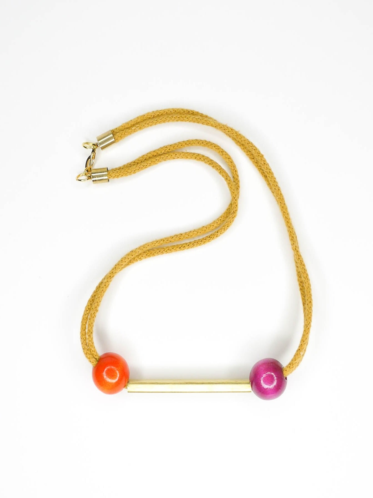 Mustard cotton rope bar necklace with a brass bar and contrasting wooden beads either side in orange and pink with a brass clasp