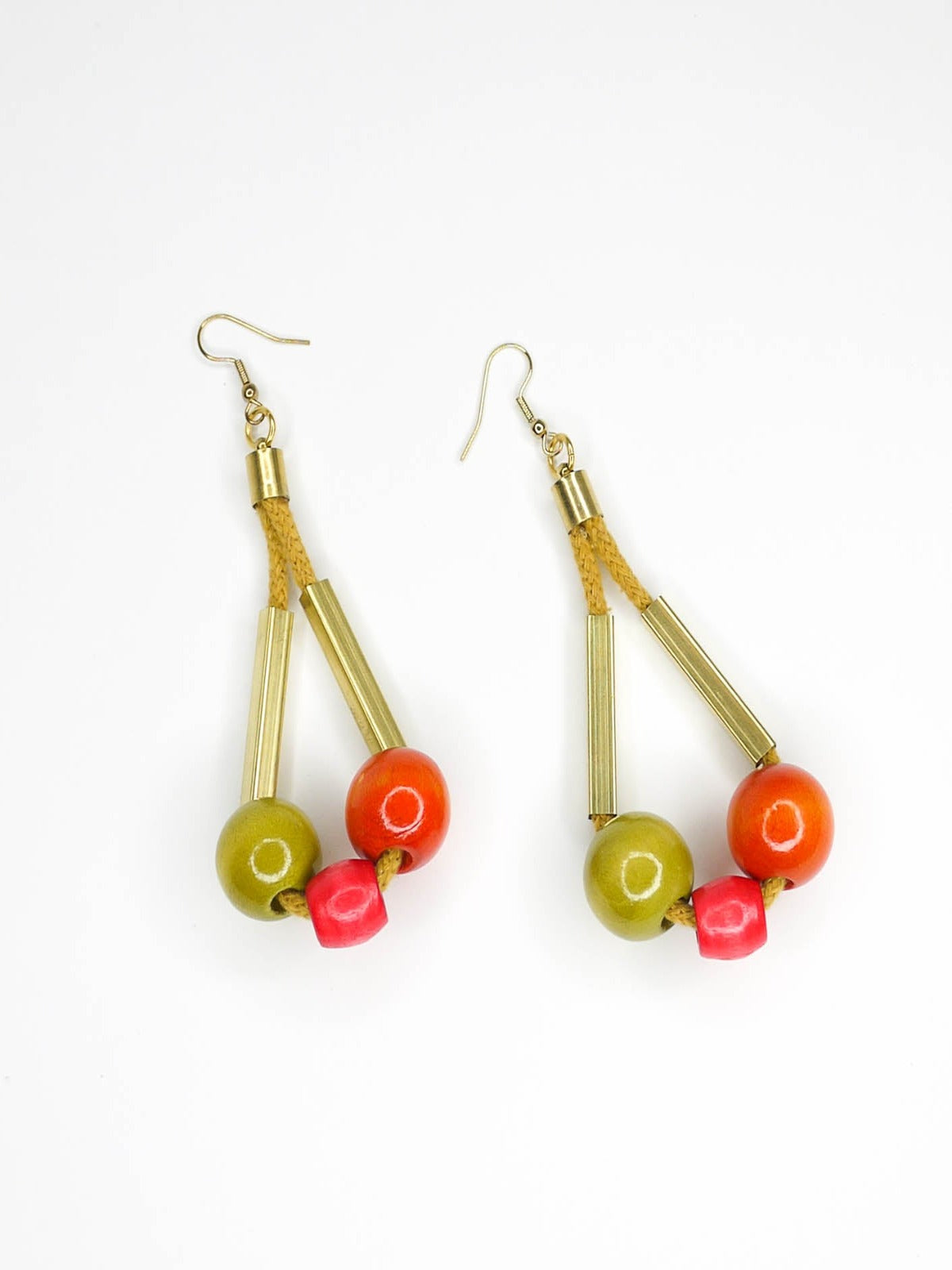 Long bead dangle statement earrings with wooden beads in watermelon, orange & green & brass tube beads strung on mustard coloured cotton rope with brass end caps, hung from gold plated brass earring hooks.