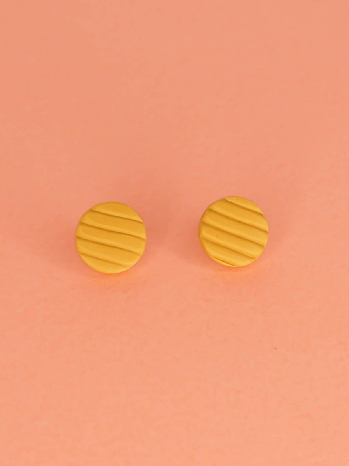 Mini mustard polymer clay studs in a textured stripe