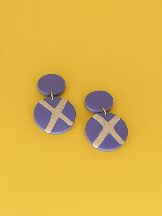 Polymer clay dangle statement earrings with a periwinkle blue stud connected to a periwinkle blue circle with a granite cross in the centre