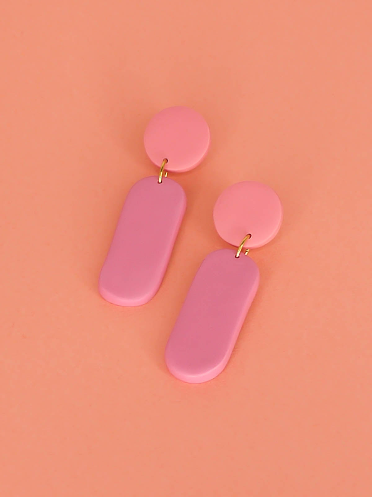 Pink colour block dangle stick earrings in two tones of pink with a long rectangle and circle disk made out of lightweight polymer clay