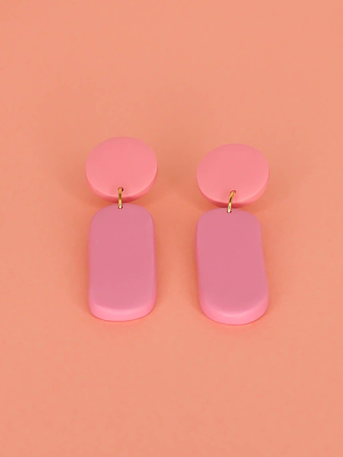 Pink colour block dangle stick earrings in two tones of pink with a long rectangle and circle disk made out of lightweight polymer clay