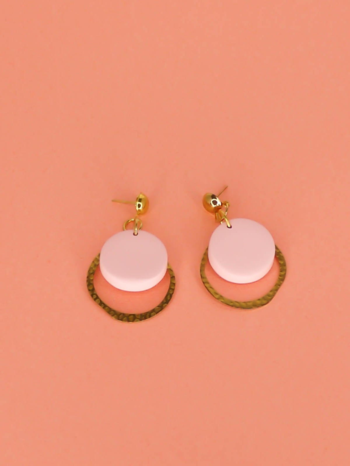 Geometric modern hoop dangle earrings with a textured brass hoop and a pastel pink polymer clay disk with gold plated brass studs