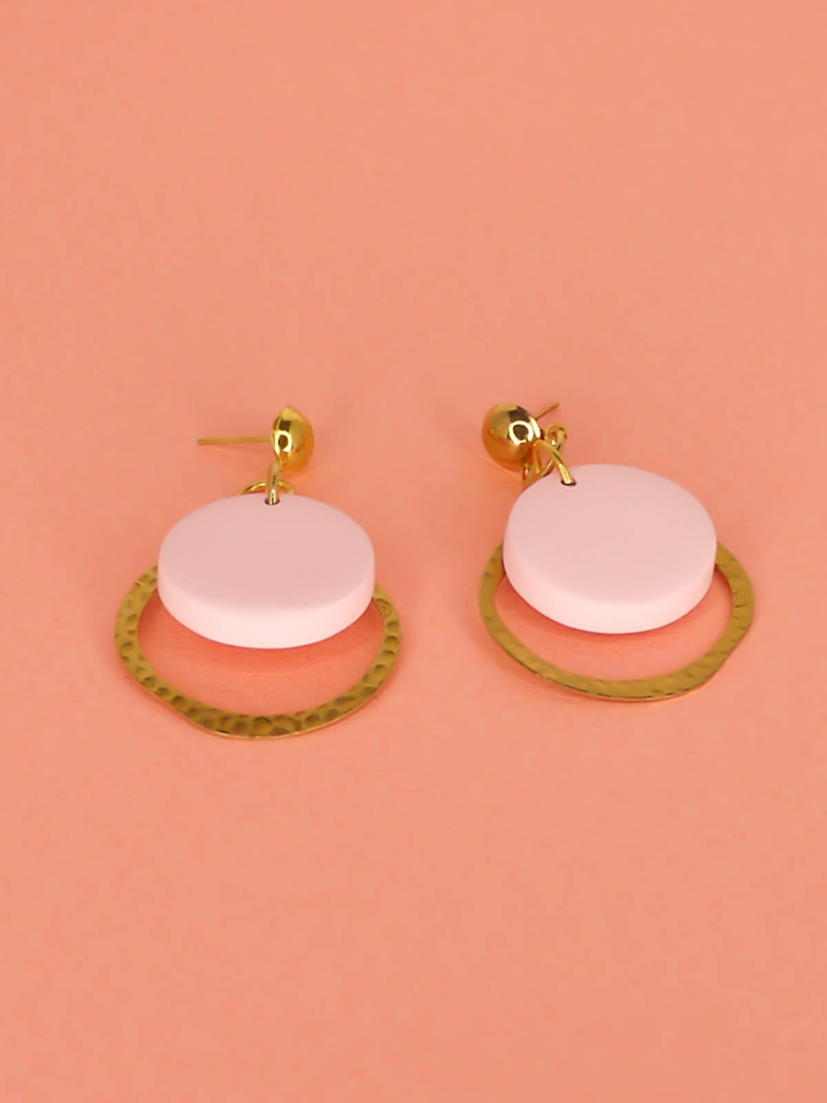 Geometric modern hoop dangle earrings with a textured brass hoop and a pastel pink polymer clay disk with gold plated brass studs