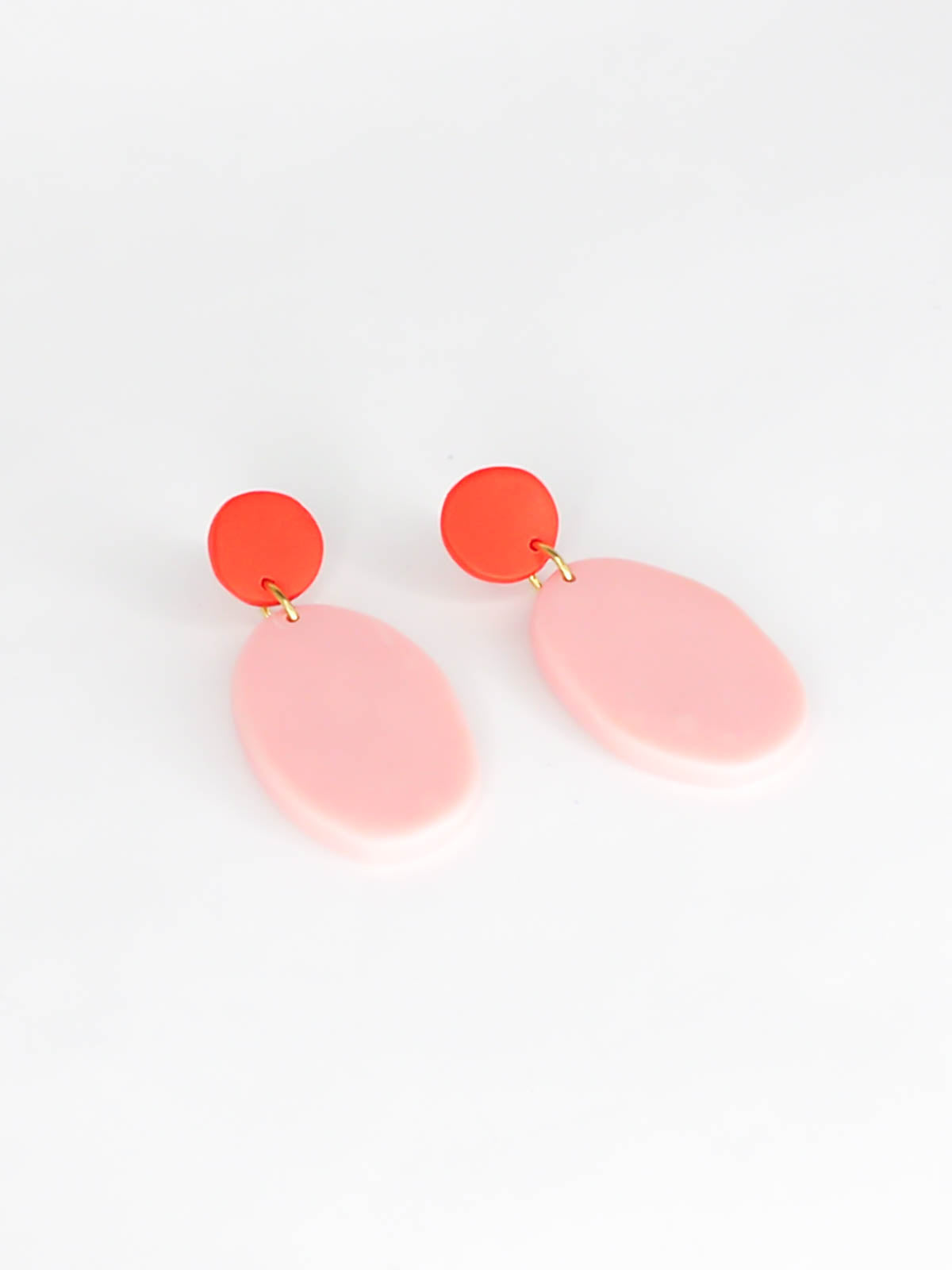 Colour block polymer clay pebble earrings in pink with a red stud and stainless steel posts