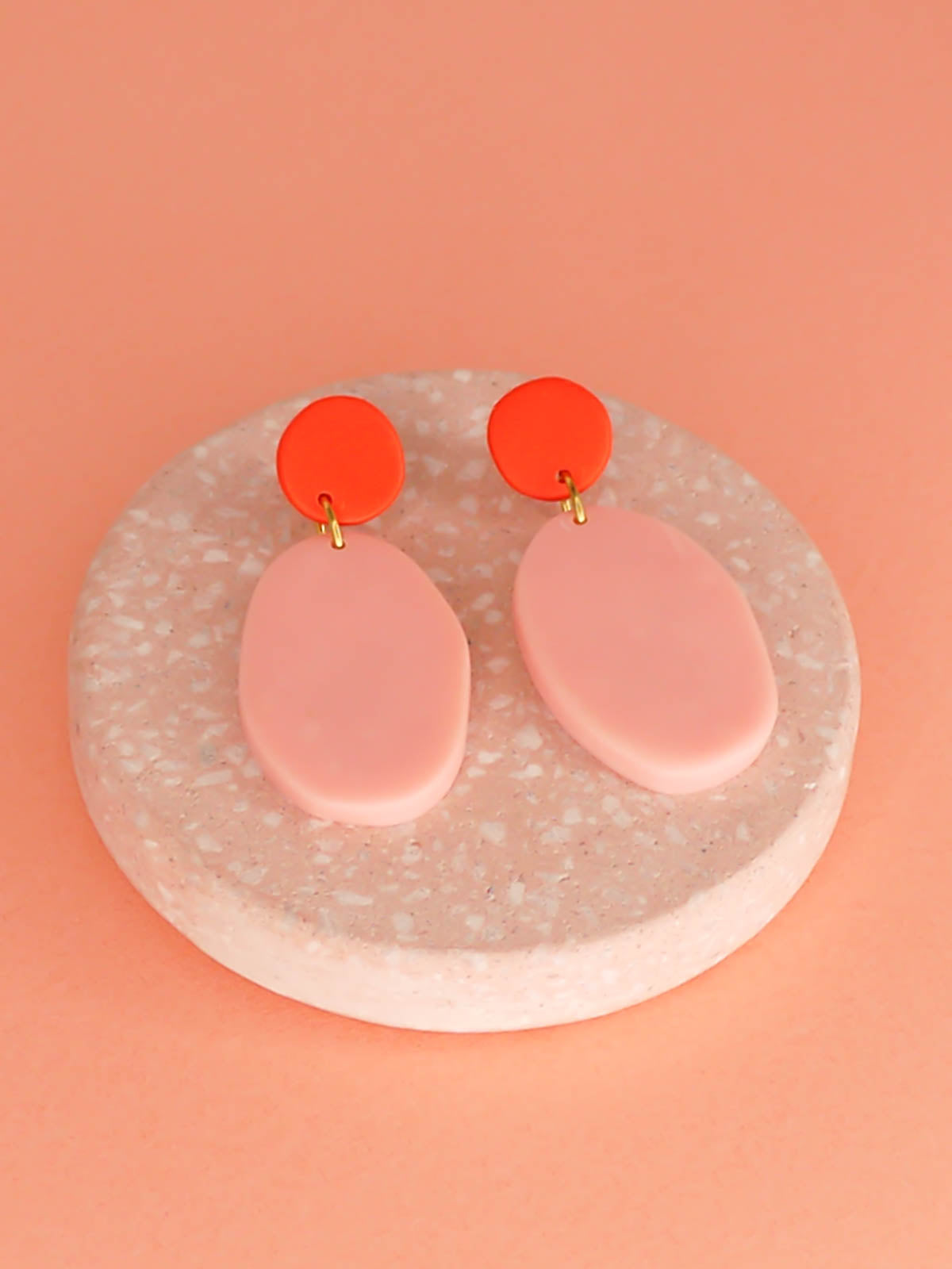 Colour block polymer clay pebble earrings in pink with a red stud and stainless steel posts