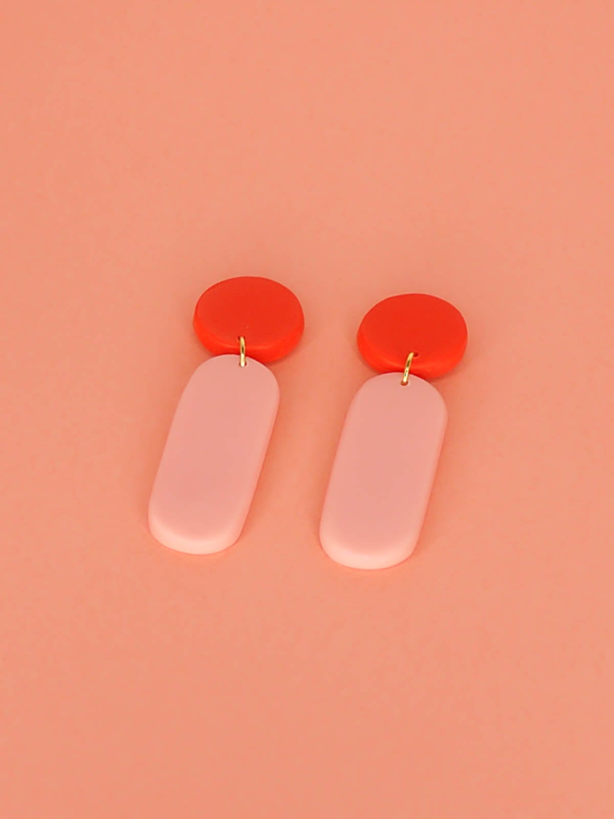 Statement dangle earrings with a rectangle pink stick dangle and red stud, with stainless steel posts, made out of lightweight polymer clay