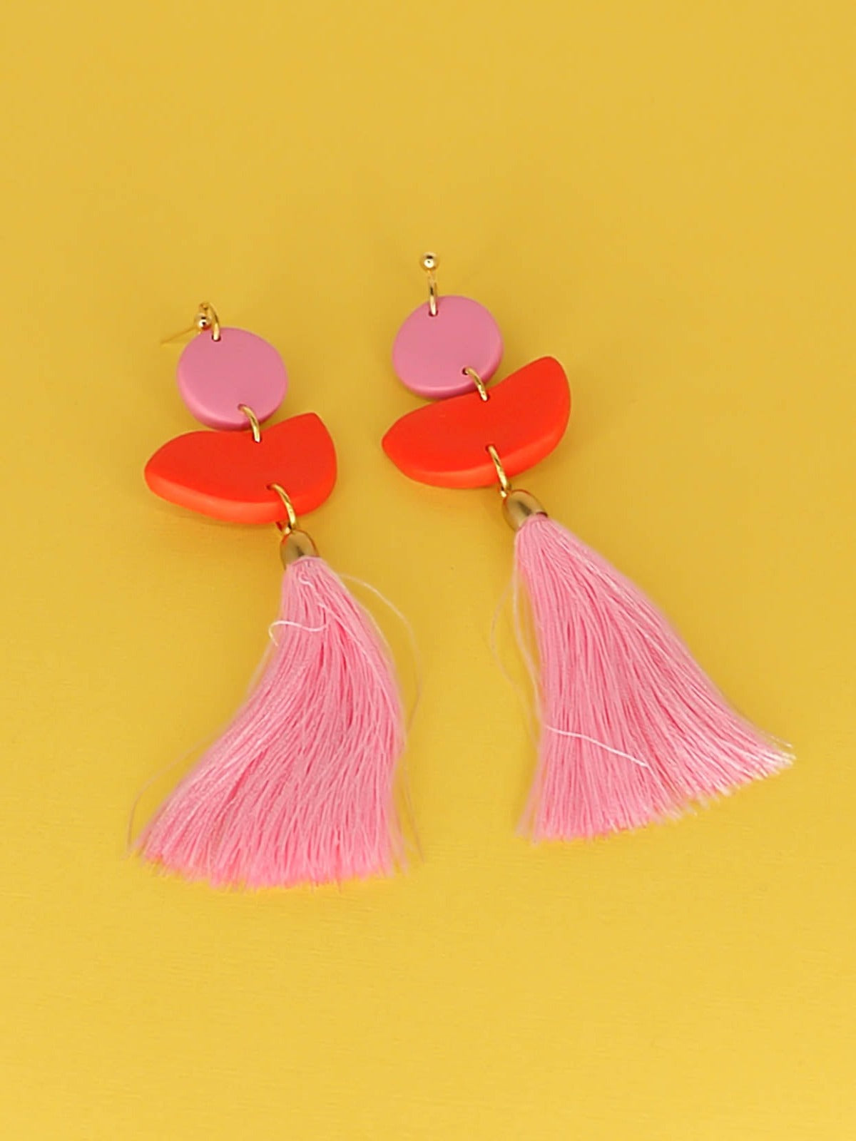 Statement dangle earrings with 24k gold plated ball studs connected to a pink polymer clay circle & a red polymer clay semi circle with a pale pink long tassel