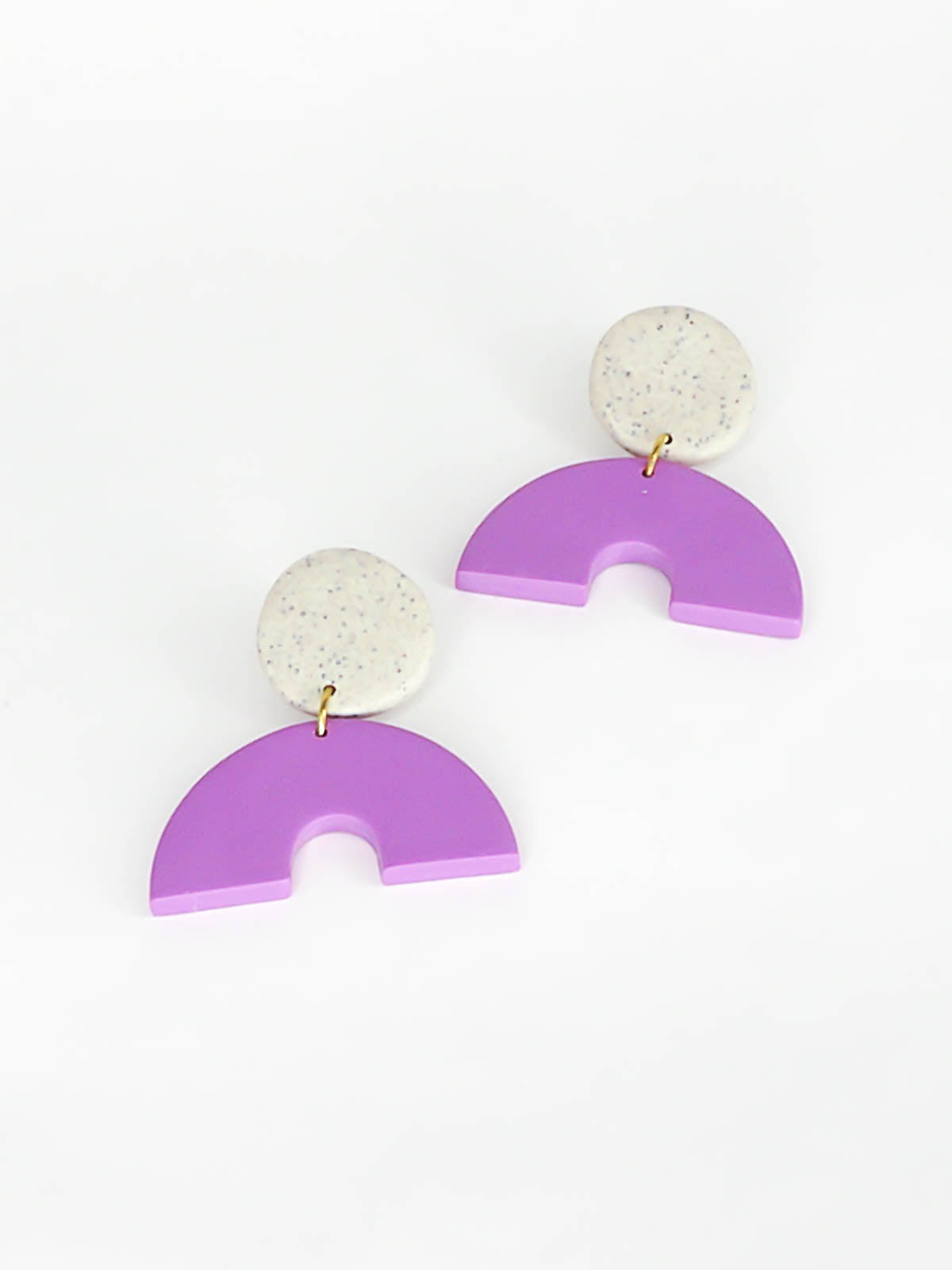 Geometric arch dangle earrings with a purple arch connected to a granite stud with stainless steel posts, made out of lightweight polymer clay