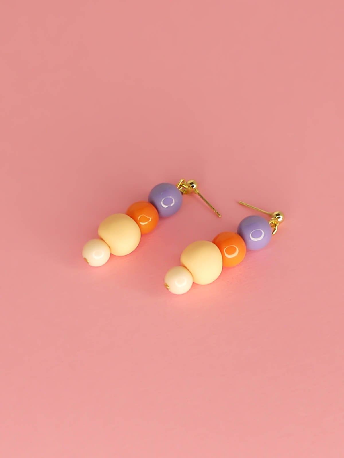 Pastel colour block bead drop earrings with purple, orange & pink round glass beads & a hand rolled polymer clay bead in peach, hung from 24k gold plated brass ball studs