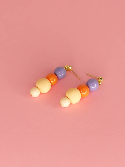 Pastel colour block bead drop earrings with purple, orange & pink round glass beads & a hand rolled polymer clay bead in peach, hung from 24k gold plated brass ball studs