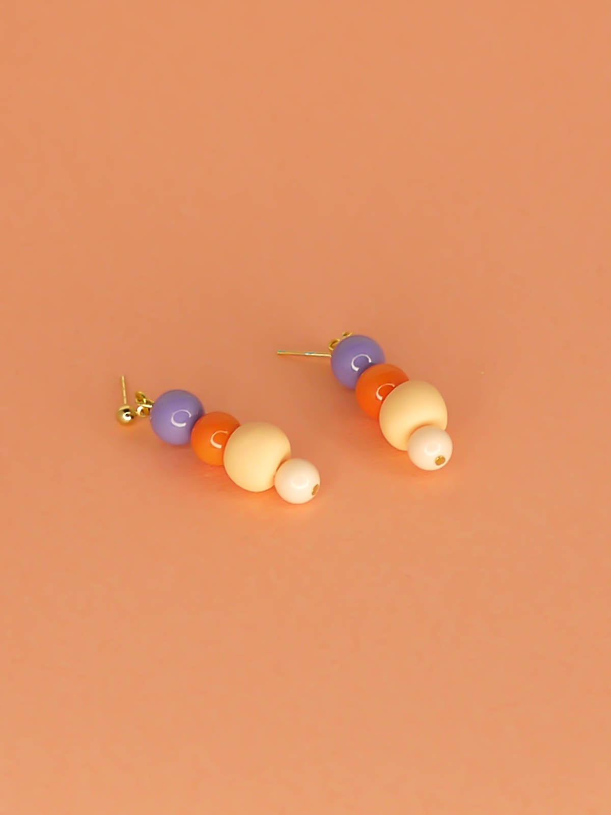 Pastel colour block bead drop earrings with purple, orange & pink round glass beads & a hand rolled polymer clay bead in peach, hung from 24k gold plated brass ball studs