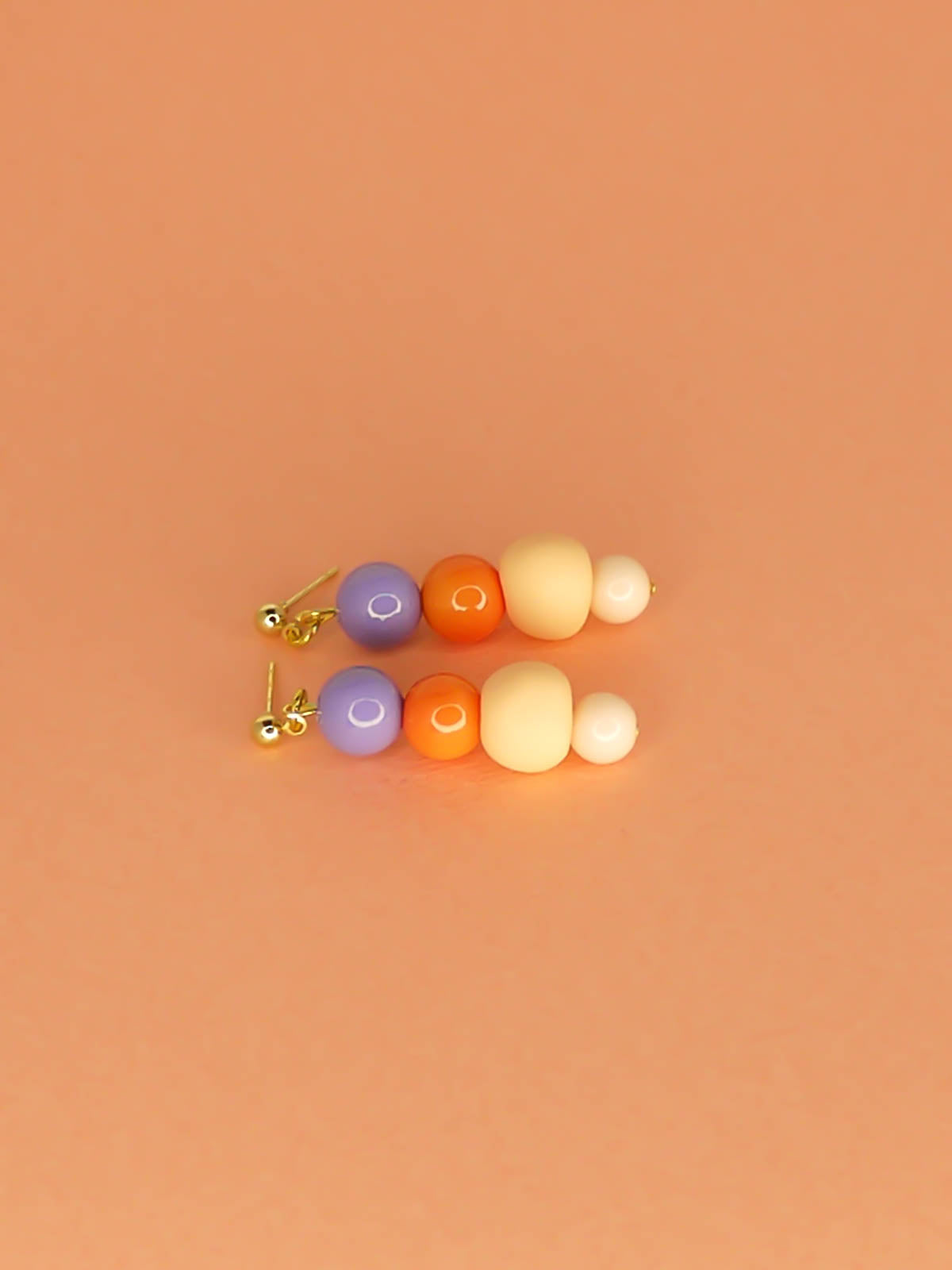 Pastel colour block bead drop earrings with purple, orange & pink round glass beads & a hand rolled polymer clay bead in peach, hung from 24k gold plated brass ball studs