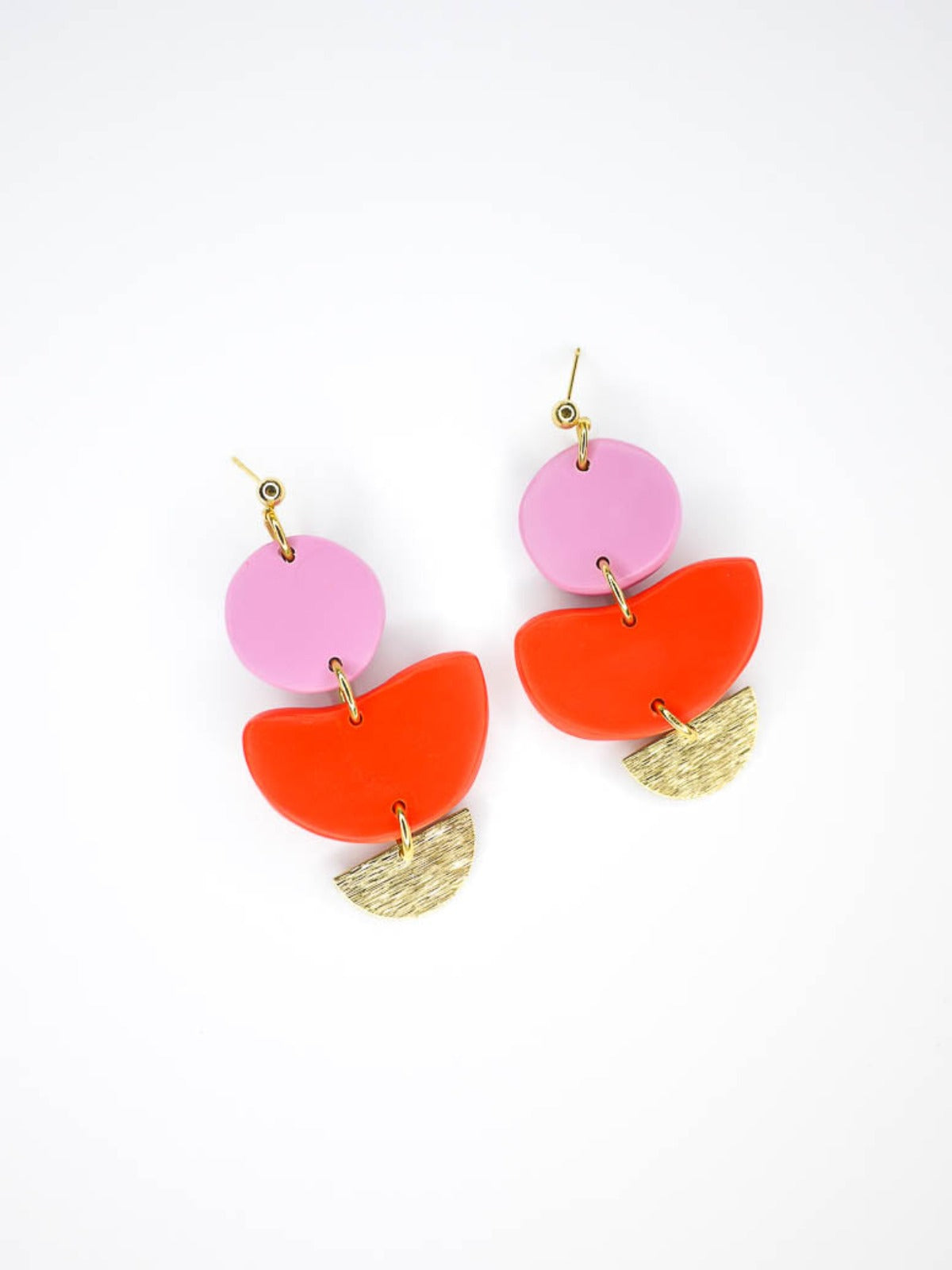 3 tier geometric colour block dangle earrings with gold plated ball studs connected to a fuchsia polymer clay circle & red clay semi circle with a textured brass semi circle charm