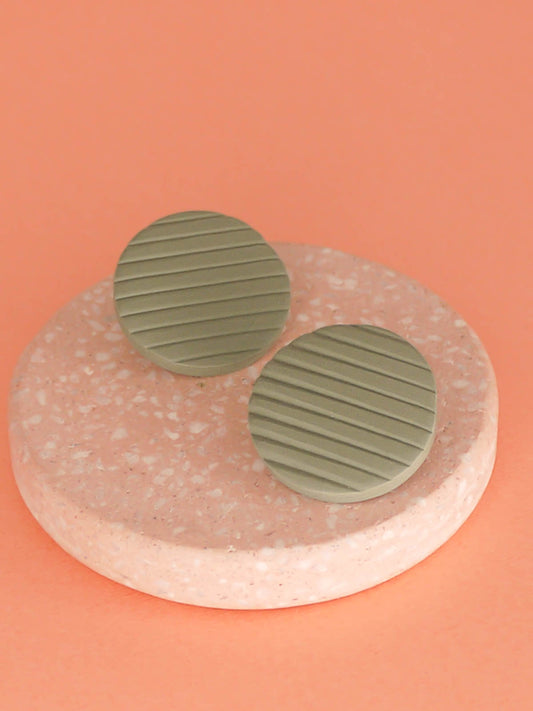 Polymer clay sage green disk stud earrings with a textured stripe and stainless steel posts