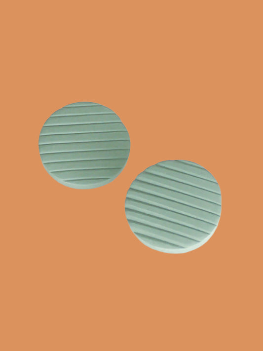 Polymer clay sage green disk stud earrings with a textured stripe and stainless steel posts