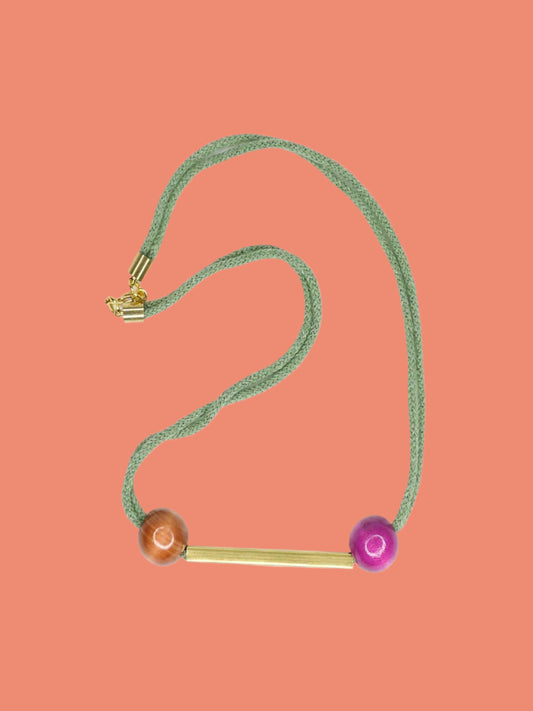 Geometric statement necklace with sage green cotton rope and a brass bar in the centre with wooden beads in pink and brown on either side with a brass bar closure