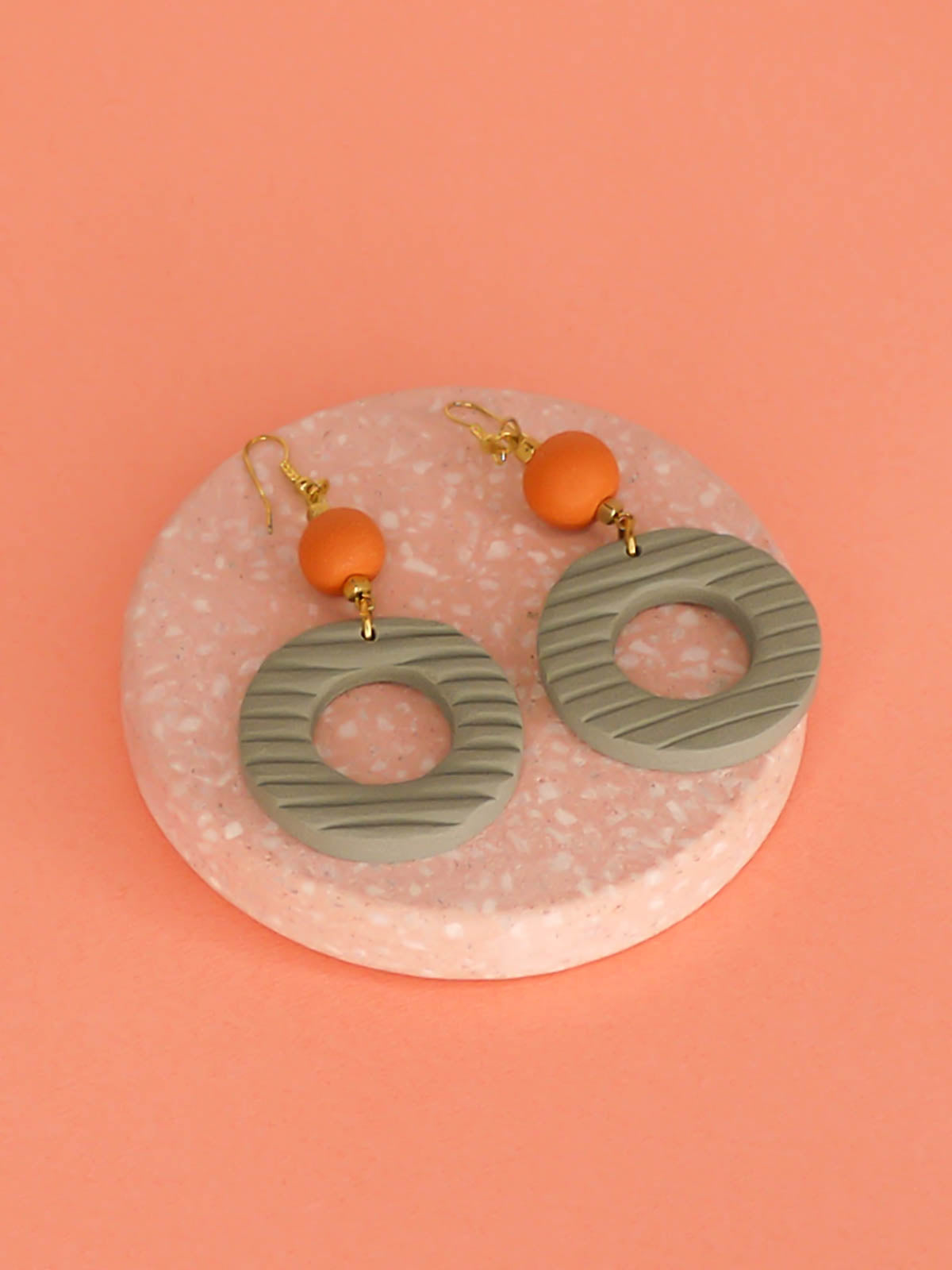 Geometric polymer clay statement dangle earrings with sage striped textured hoops, connected to terracotta ball beads and hung from brass ear wires.