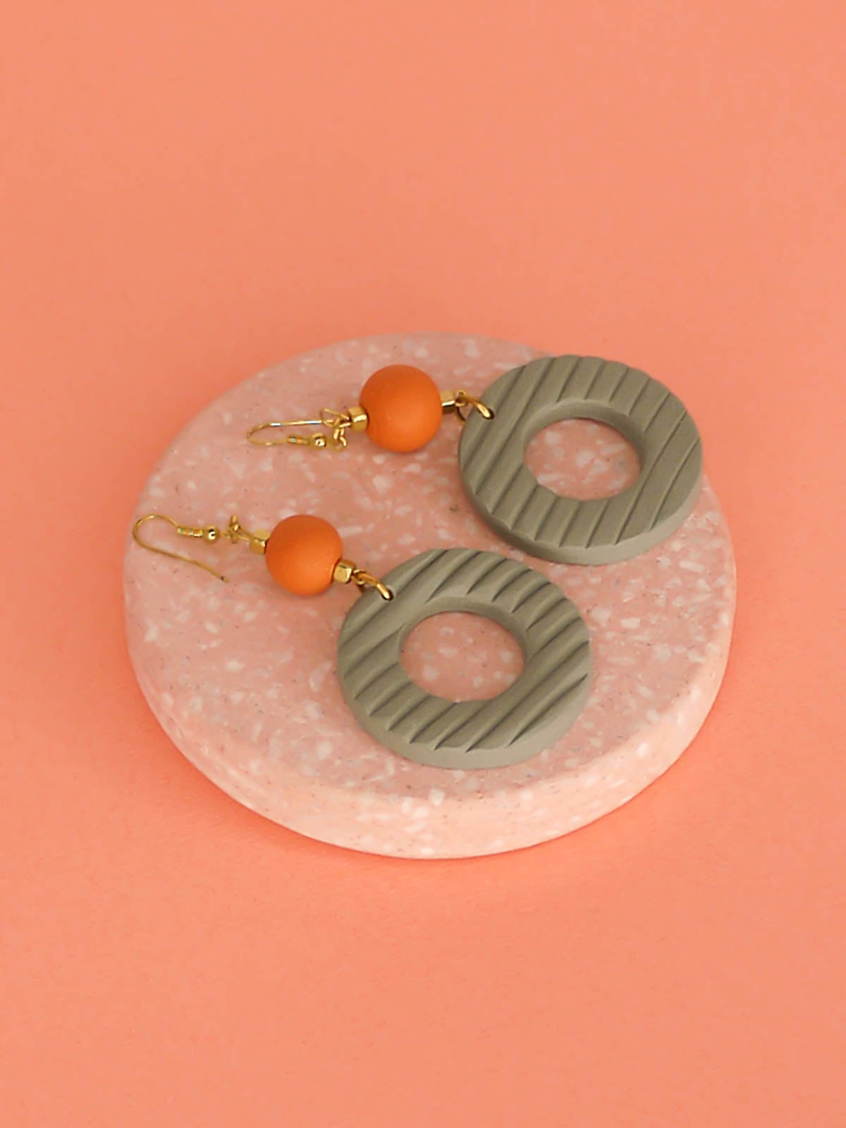 Geometric polymer clay statement dangle earrings with sage striped textured hoops, connected to terracotta ball beads and hung from brass ear wires.