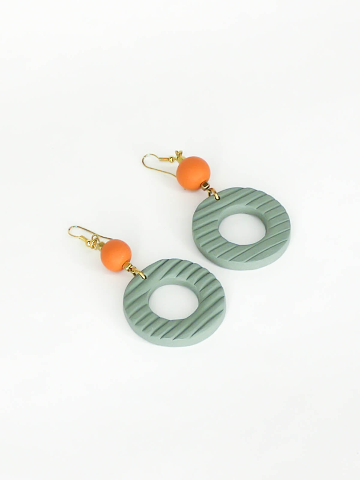 Geometric polymer clay statement dangle earrings with sage striped textured hoops, connected to terracotta ball beads and hung from brass ear wires.