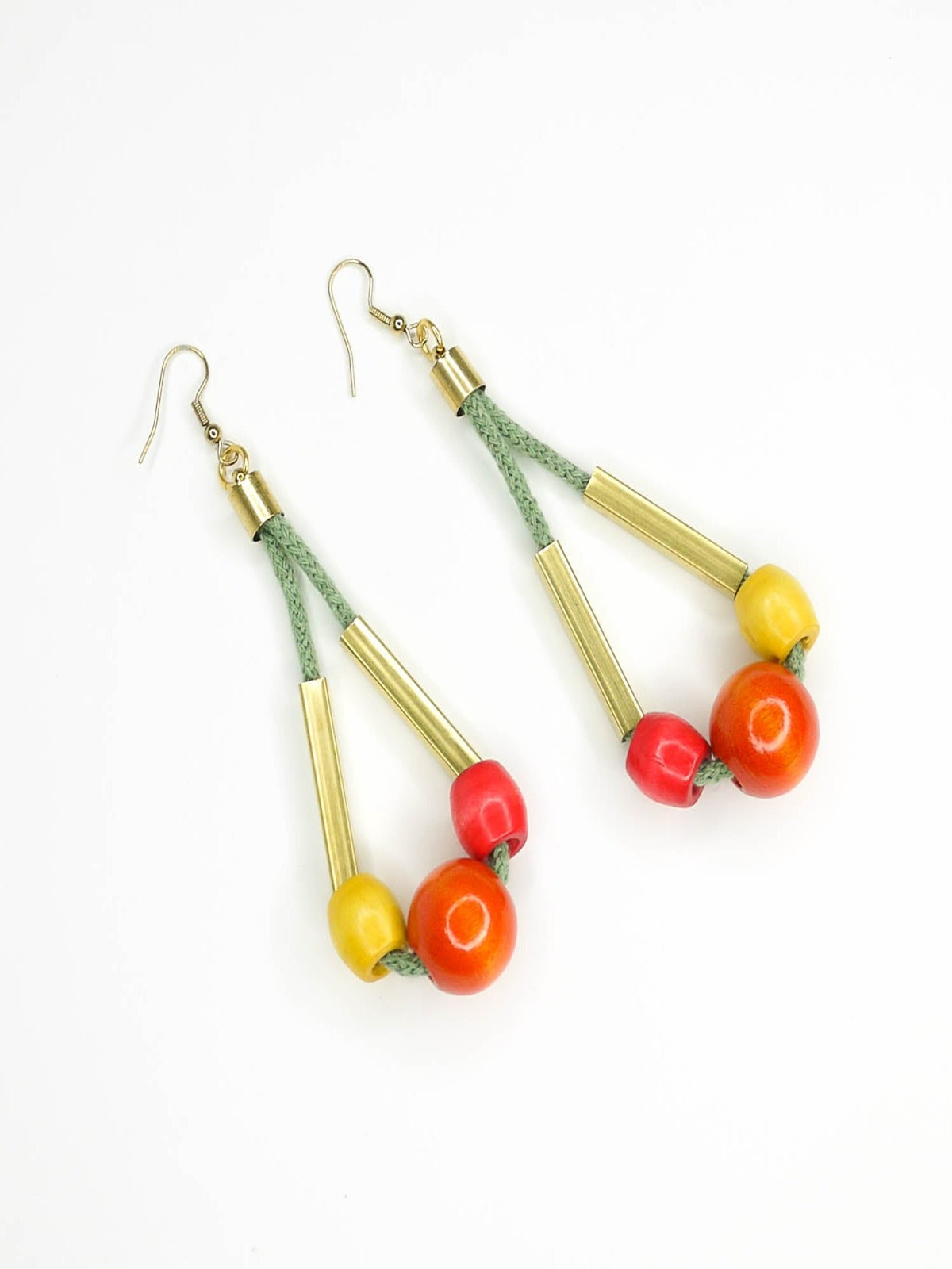 Long bead dangle statement earrings with wooden beads in watermelon, orange & green & brass tube beads strung on mustard coloured cotton rope with brass end caps, hung from gold plated brass earring hooks.