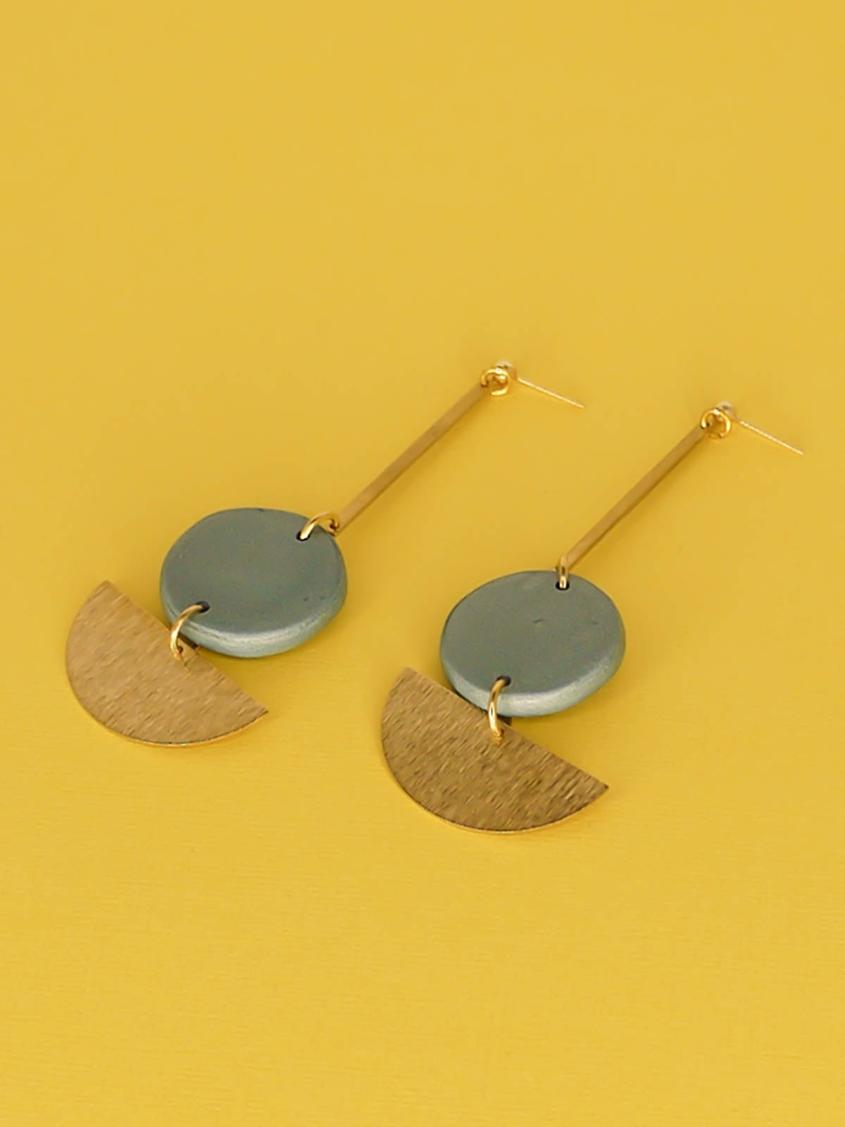 Dangle geometric statement earrings with a gold plated ball stud, a brass stick with a polymer clay round metallic circle in turquoise connected to a textured brass semi circle